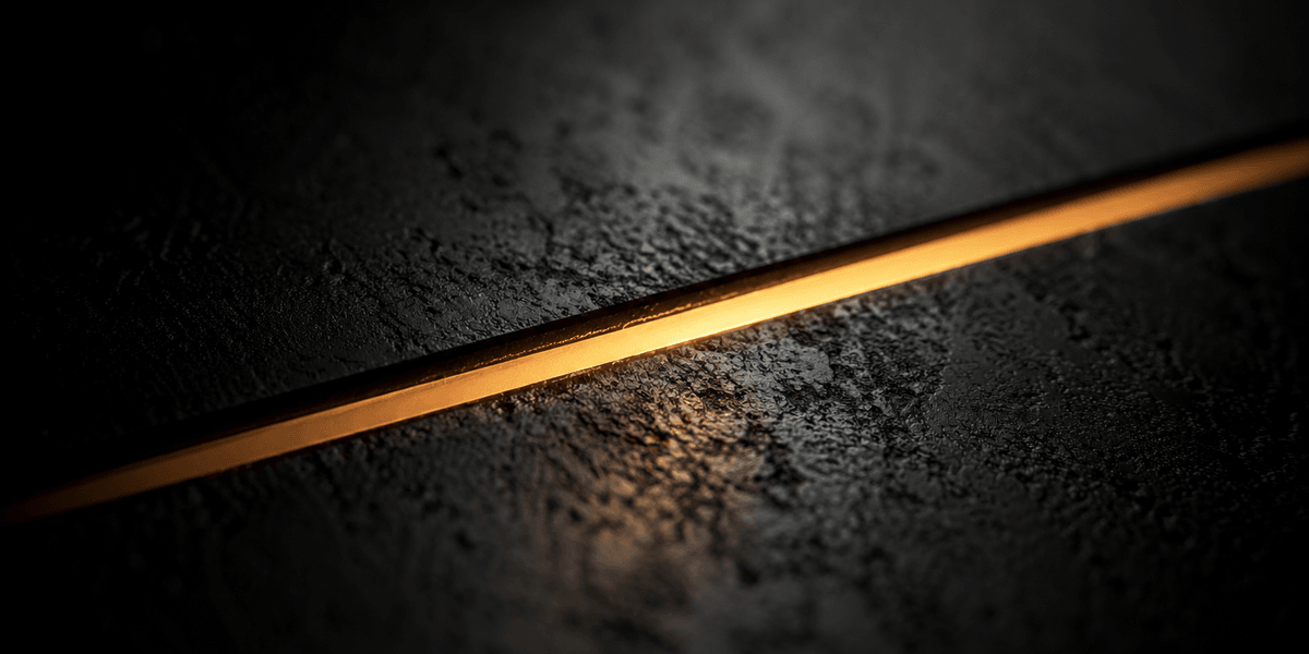 A single thin, sharply defined line of light catching along a dark textured surface