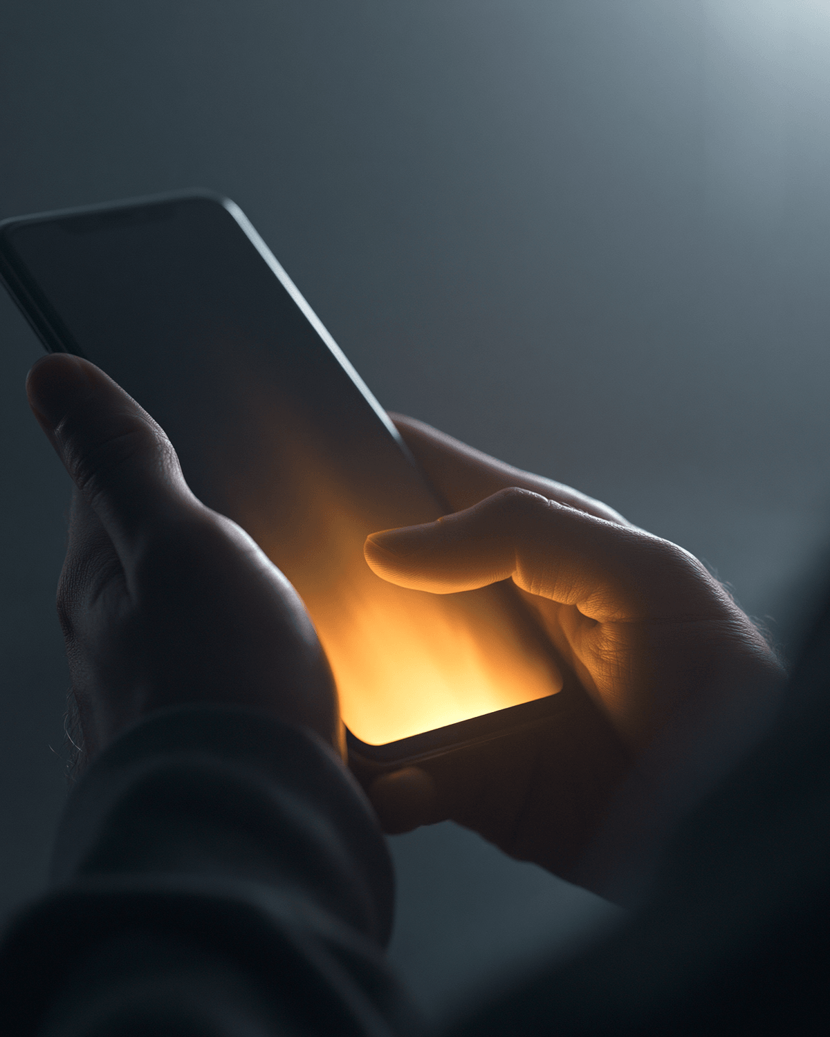 Hand holding a phone with a soft screen glow
