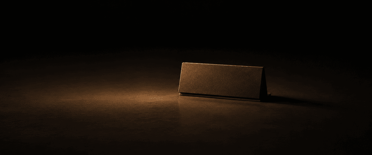 A single blank sign board standing upright and lit in an otherwise dark space, with nothing written across its surface — echoing how a name alone gives an AI system nothing to actually say